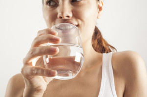 64786571 - young woman drinking  glass of water