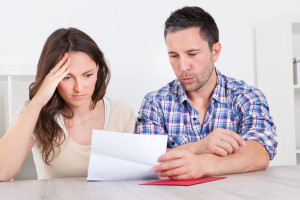 24284604 - portrait of a worried young couple looking at paper